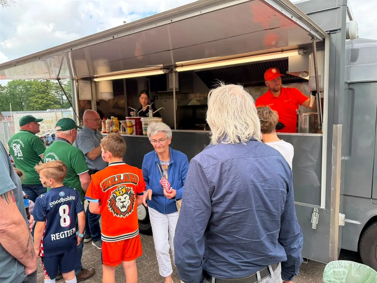 Gildeleden, vrienden en kinderen bij de foodtruck op het gildeterrein
